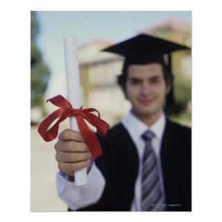 Young man in graduation gown holding scroll, posters