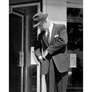 Man looking into pocket outside store Poster Print (18 x 24)